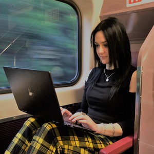 UNE law student Breezy Altmann studies on her laptop while commuting by train
