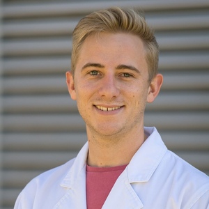 UNE Bachelor of Science (Hons) graduate and PhD student Matthew Hilliar in white lab coat