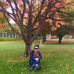 UNE student amid autumn colours Armidale campus