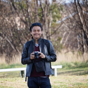 UNE graduate poses on campus with camera