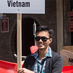 UNE student in sunglasses with Vietnam sign in cultural parade