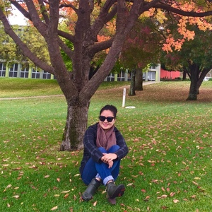 UNE student amid autumn colours Armidale campus
